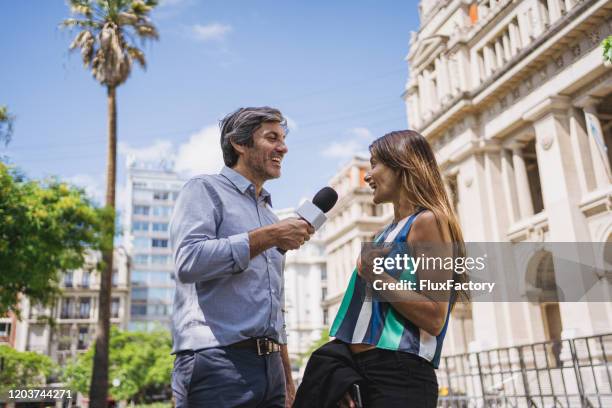 giornalista allegra che intervista una bella donna in una città - intervista-giornalistica foto e immagini stock