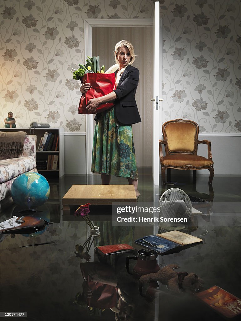 Woman with grocery in flooded room