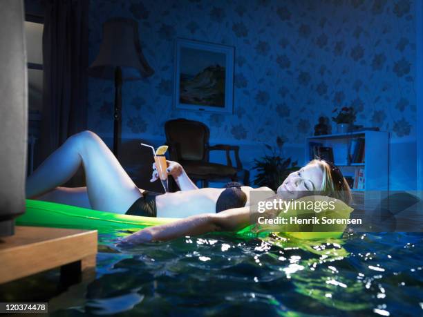 young woman sunbading in flooded room - huis overstroming stockfoto's en -beelden