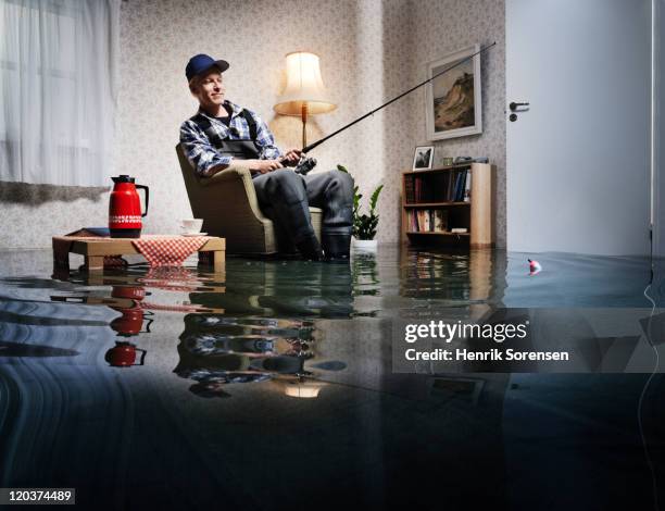 young man fishing in flooded room - funny hobbies stock pictures, royalty-free photos & images