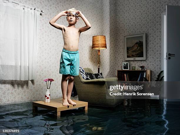 young boy ready to swim in flooded room - flood preparation stock pictures, royalty-free photos & images