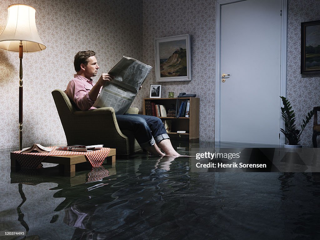 Man with newspaper flooded room