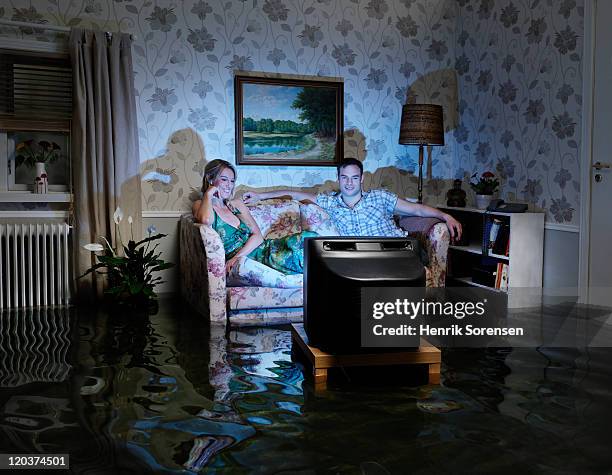 pair in front of tv in flooded room - blind spot stock pictures, royalty-free photos & images