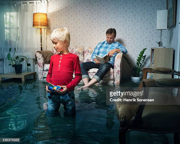 boy playing in flooded room - house destruction stock pictures, royalty-free photos & images