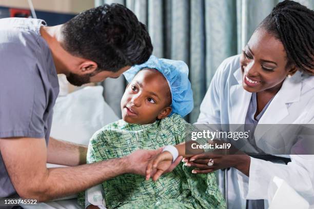 docteur, infirmière aidant la fille s’asseyant sur le lit d’hôpital - bracelet d'identification photos et images de collection