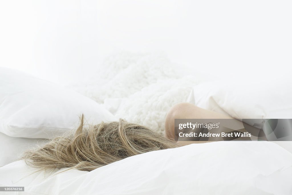 Rear view of woman's head & shoulders on a pillow
