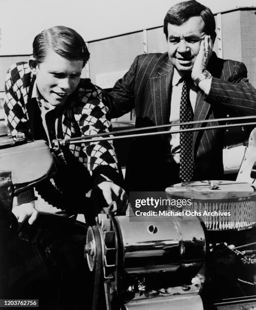 American actors Ron Howard and Tom Bosley as Richie Cunningham and his father Howard Cunningham, tinkering with a car engine in a scene from the...