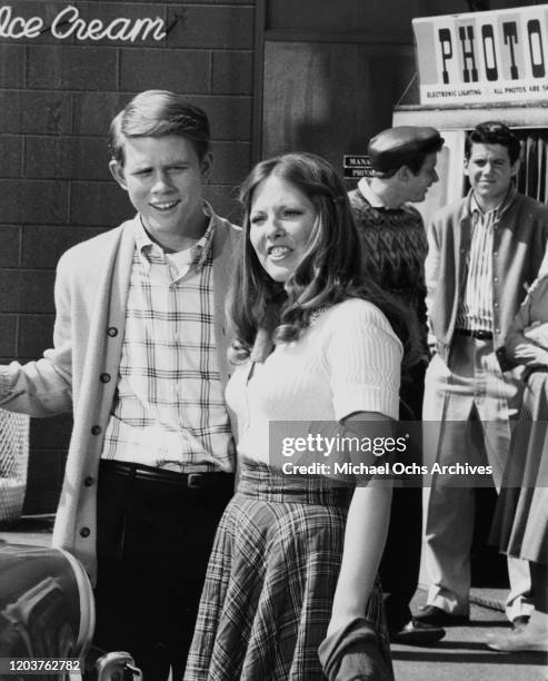 American actors Ron Howard and Christina Hart on the set of the television sitcom 'Happy Days', USA, circa 1975. In the background are co-stars Donny...