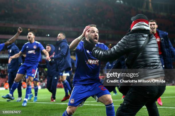 Mathieu Valbuena of Olympiacos celebrates their victory with a fan during the UEFA Europa League round of 32 second leg match between Arsenal FC and...
