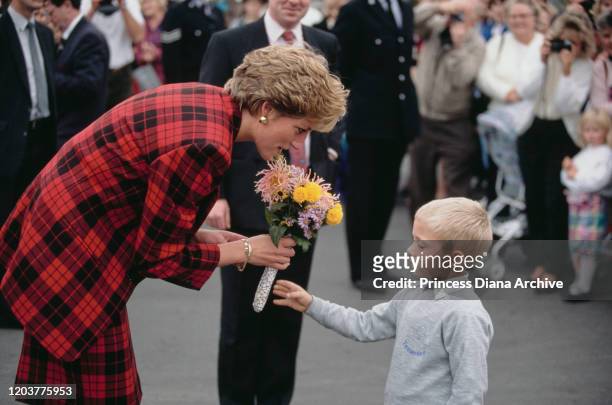 Diana, Princess of Wales during a visit to Tenterden in Kent, 18th October 1990. She is wearing a red and black checked suit by Escada.
