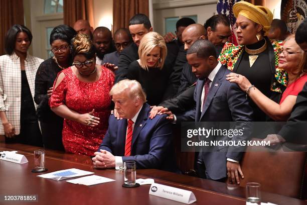 President Donald Trump stands in a prayer circle during a meeting with African-American leaders in the Cabinet Room of the White House in Washington,...