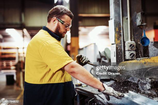 travailleurs de col bleu dans l'industrie - broyage et découpage des barres en métal - australian culture stock photos et images de collection