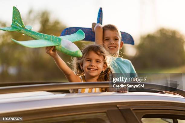 day dreaming of a beautiful kids with airplane toy up in the air - sunroof stock pictures, royalty-free photos & images