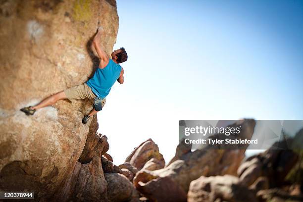 male rock climber bouldering. - boulderen stockfoto's en -beelden