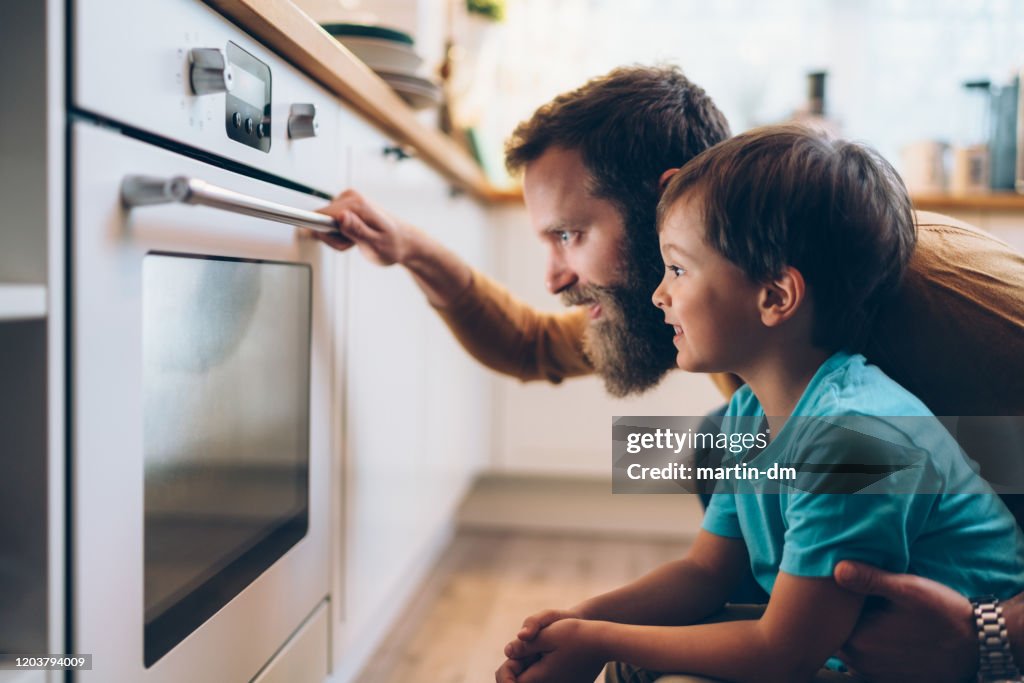 Father and son cooking dinner at home