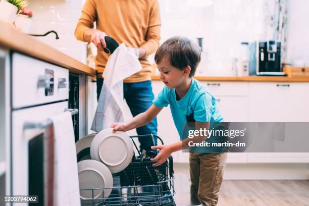 hijo ayudando a papá con el lavaplatos. concepto chores - unloading fotografías e imágenes de stock