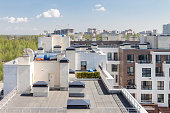 Flat roof with air conditioners on top modern apartment house building exterior mixed-use urban multi-family residential district area development.