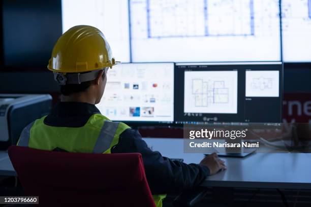 industrial engineering works in front of a monitoring screen in the control center. technology and ai concept. - service design stock-fotos und bilder
