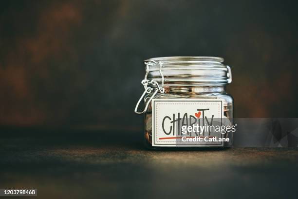 charity jar filled with money - charity and relief work stock pictures, royalty-free photos & images