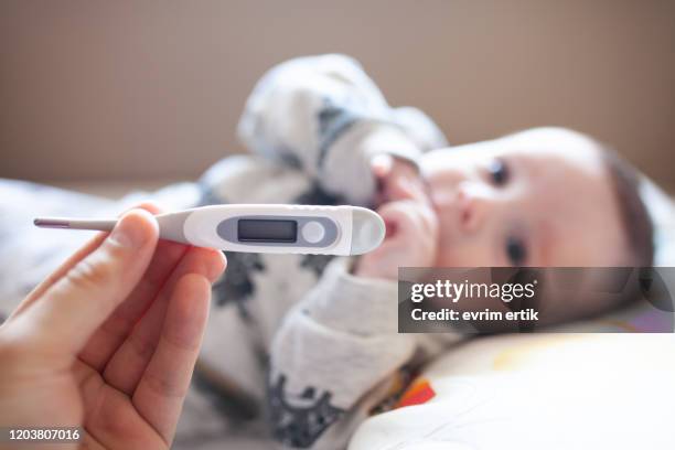 thermometer to measure the temperature of a sick child stock photo - hot babe stock pictures, royalty-free photos & images