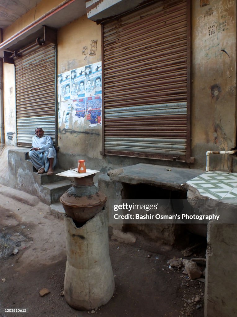 A senior man sits idle by a street