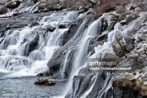 the hraunfossar waterfalls, in iceland, during winter. - hraunfossar stock pictures, royalty-free photos & images