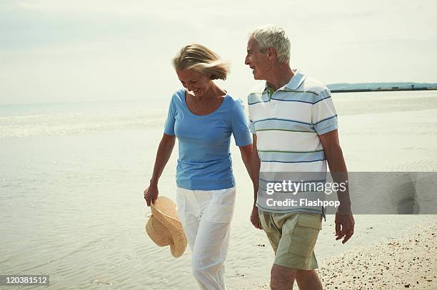 senior couple enjoying day out at the beach - short shorts stock pictures, royalty-free photos & images