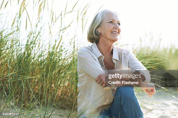 senior woman relaxing at the beach - 60 64 ans photos et images de collection