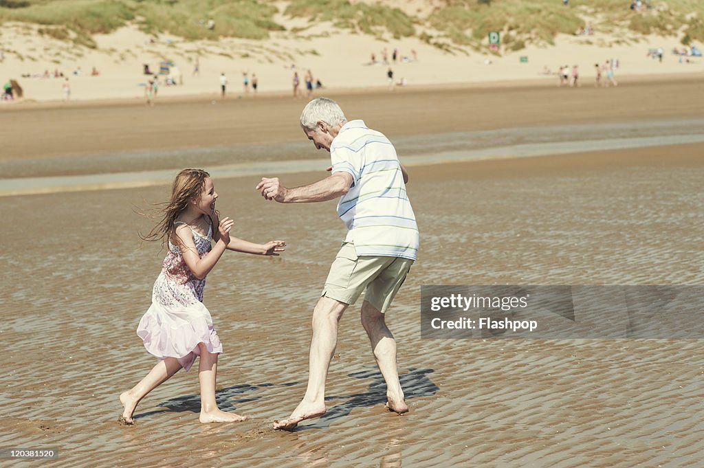 Grandfather at the beach with granddaughter