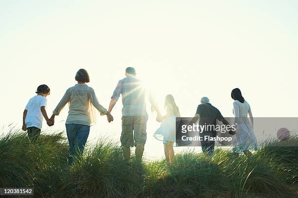 three generation family enjoying day out together - holding hands stock-fotos und bilder