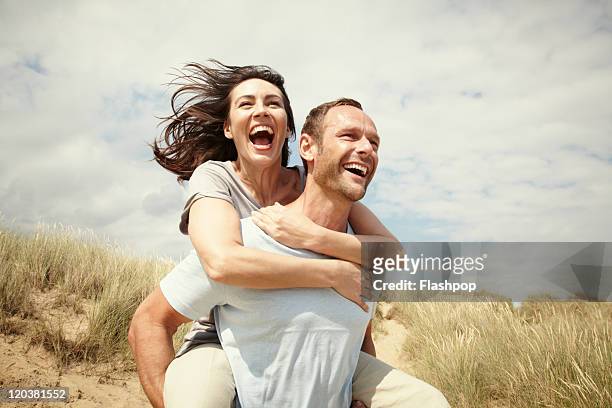 couple enjoying day out at the beach - cheerful stock pictures, royalty-free photos & images