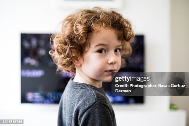 a child standing in front of tv, looking directly to the camera - girl 6 7 stock pictures, royalty-free photos & images