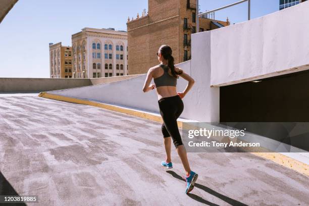 woman runner climbing parking garage in city - self discipline imagens e fotografias de stock