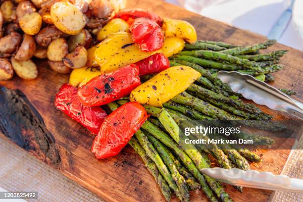 abundant platter of grilled and roasted asparagus, red and yellow peppers, and roasted potatoes - colorful vegetables summer stock pictures, royalty-free photos & images