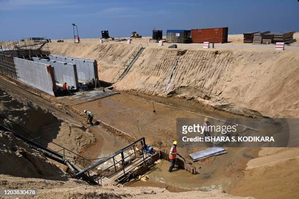 In this photograph taken on February 24, 2020 labourers work at a construction site on reclaimed land, part of a Chinese-funded project for Port...