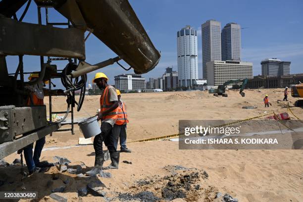 In this photograph taken on February 24, 2020 labourers work at a construction site on reclaimed land, part of a Chinese-funded project for Port...