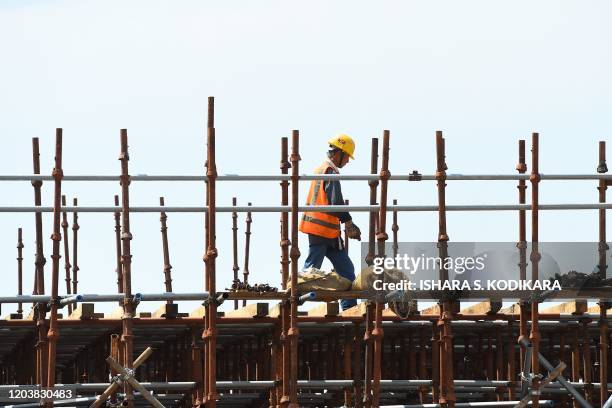 In this photograph taken on February 24, 2020 a Chinese labourer works at a construction site on reclaimed land, part of a Chinese-funded project for...