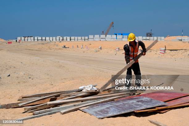 In this photograph taken on February 24, 2020 a Chinese labourer works at a construction site on reclaimed land, part of a Chinese-funded project for...