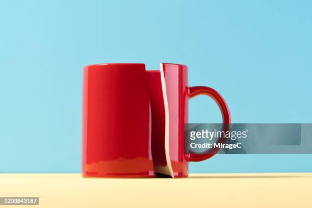 damaged red mug cup - red blue background stockfoto's en -beelden