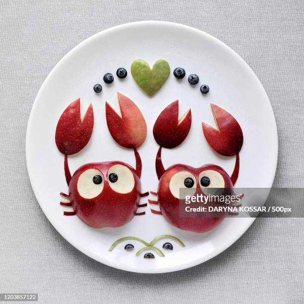 high angle view close up of crabs made out of apples on white plate, new york city, usa - apple plate stock pictures, royalty-free photos & images