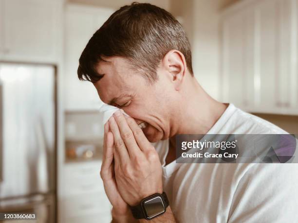 man covers nose during sneeze - sneeze stock pictures, royalty-free photos & images