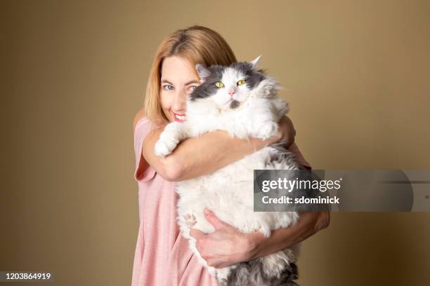femme retenant le grand chat furry - cute chubby women photos et images de collection