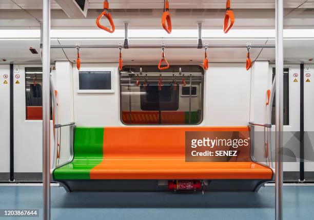 row of empty orange seats in train subway - vagón fotografías e imágenes de stock