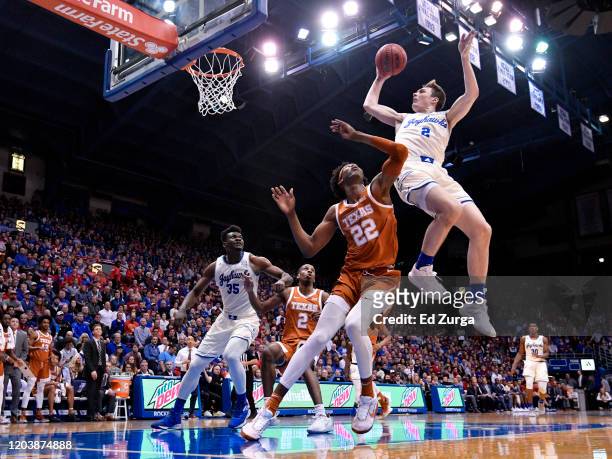 Christian Braun of the Kansas Jayhawks is fouled by Kai Jones of the Texas Longhorns as he goes up for a shot in the first half of a college...