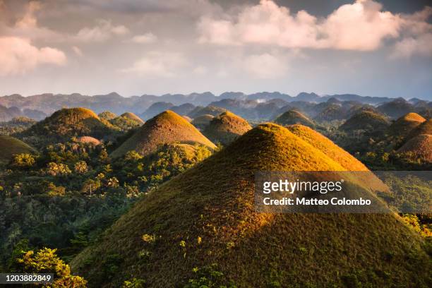 dramatic light over chocolate hills, bohol, philippines - phenomenon stock-fotos und bilder