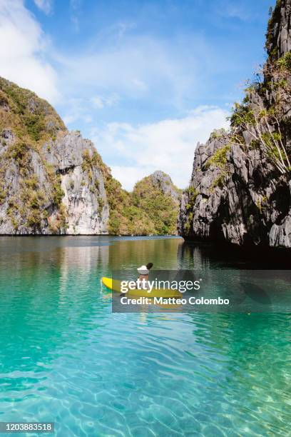 woman kayaking in a lagoon, el nido, palawan, philippines - el nido stock pictures, royalty-free photos & images