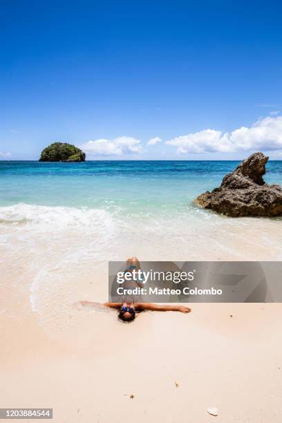 asian woman laying down on the sand, boracay island - boracay beach stock pictures, royalty-free photos & images