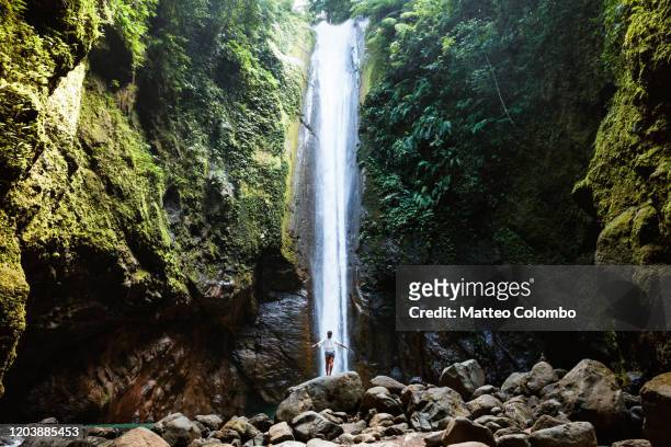 woman under tall waterfall, negros, philippines - negros oriental stock-fotos und bilder