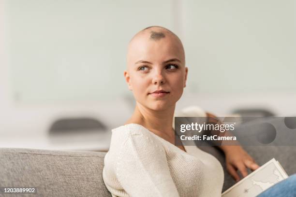 young woman with alopecia reading stock photo - cancer patient portrait stock pictures, royalty-free photos & images