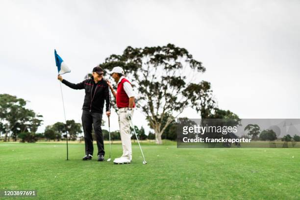 golfspeler die in de cursus spreekt - golf caddy stockfoto's en -beelden